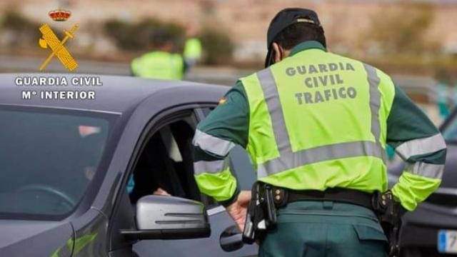 Un agente de la Guardia Civil da el alto a un coche